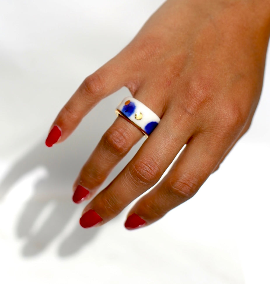 bague en porcelaine blanche émaillée en taille FR51, avec des détails à l'or liquide peint à la main avec un motif à pois bleu nuit et point à l'or précieux.