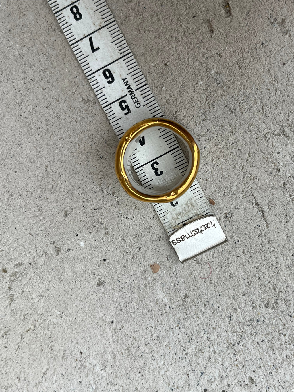 Bague type bandeau en porcelaine blanche émaillée en taille 53 FR avec un message FUCK ornées de petits motifs d'étoiles en or liquide peintes à la main.