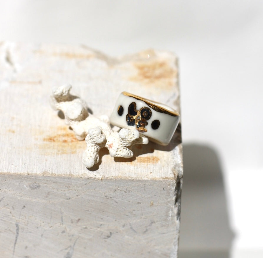 Une bague en porcelaine blanche émaillée en taille 51. Avec un motif rose noire stylisée peinte à l'or liquide avec des feuilles colorées. Avec une inscription  cachée "LOVE" en lettres dorées. Réalisée à la main à Lyon. 