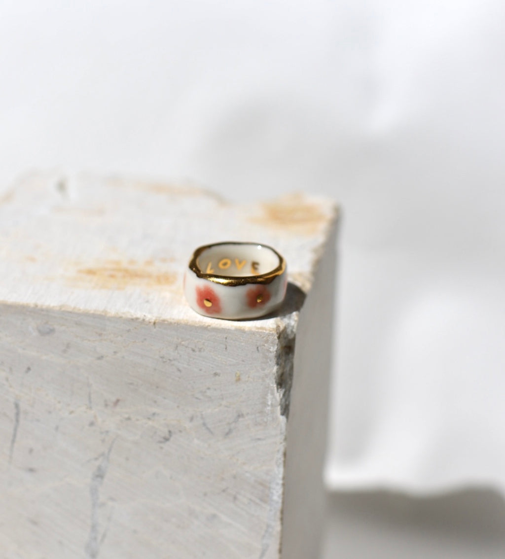 bague avec des motifs floraux roses émaillés et points d'or précieux sur un anneau blanc en porcelaine taille 53 FR.