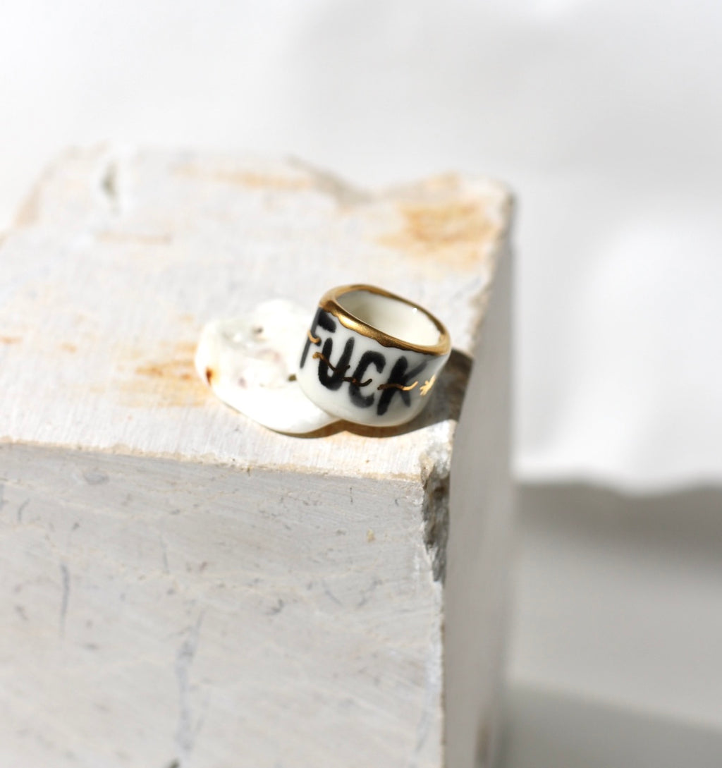 bague en porcelaine inscription FUCK noire sur bague porcelaine bord or