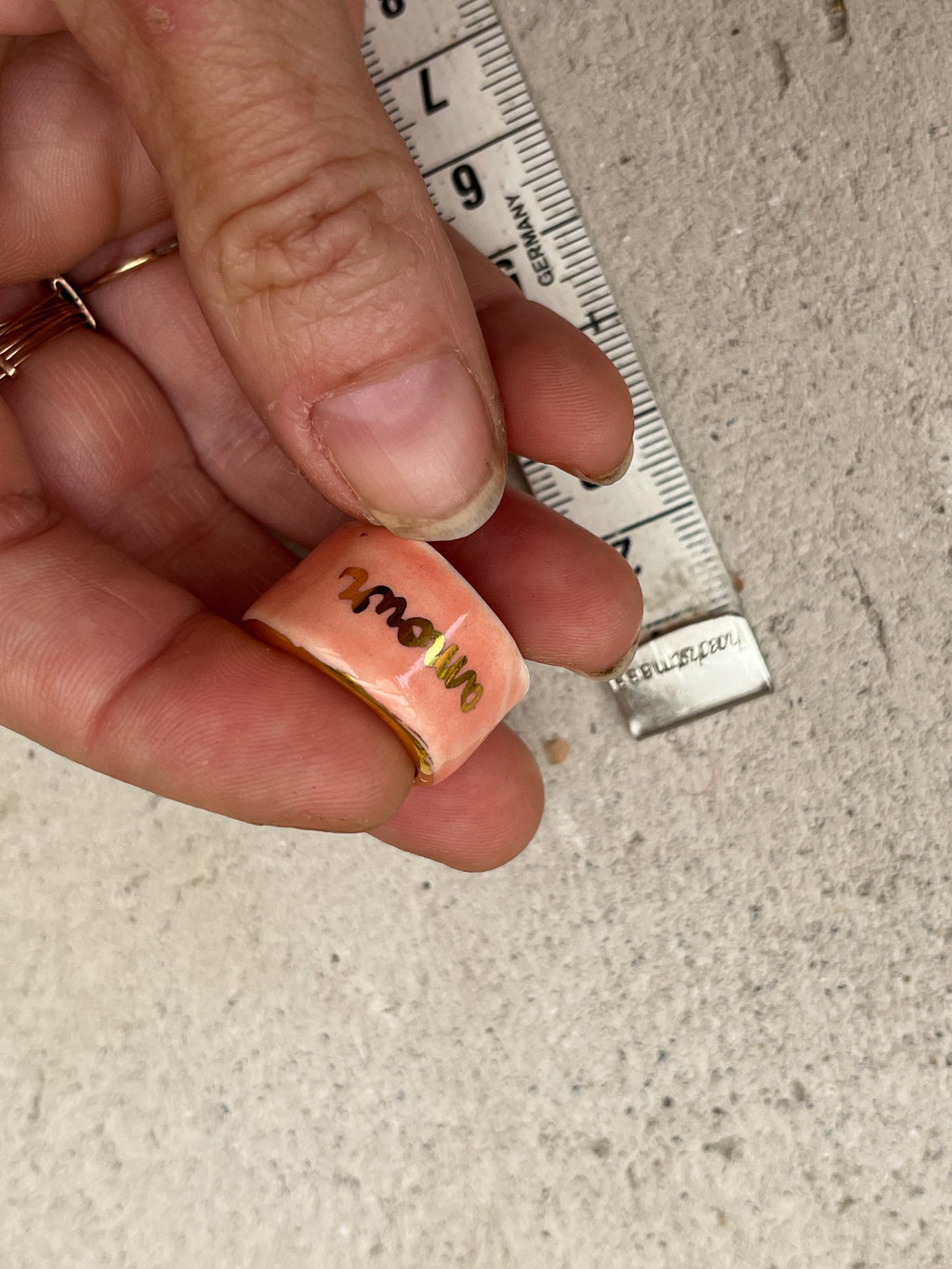 bague en porcelaine rose émaillée taille 52 FR avec une inscription "amour" écrite ainsi qu'un œil protecteur dessiné à la main à l'or liquide.