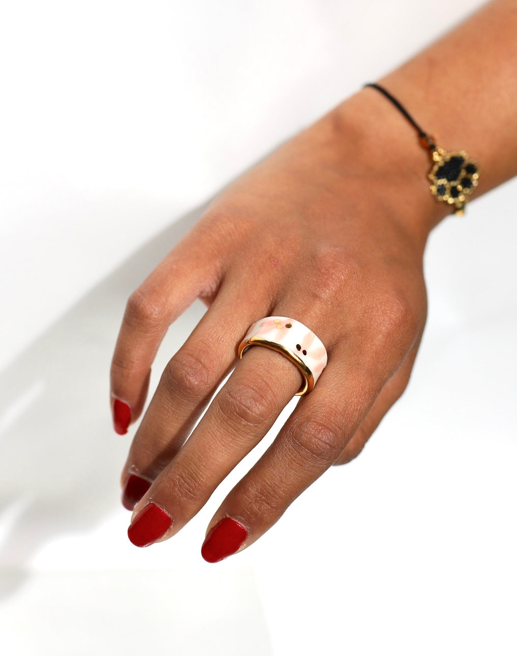 bague en porcelaine blanche émaillée en taille 53 Fr, à motif fleurs rose et de points à l'or liquide fait à la main avec un liseré doré sur sa tranche.