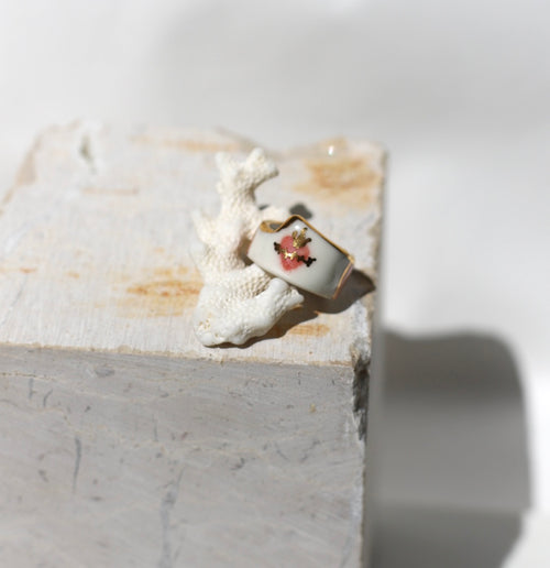 Bague large en porcelaine blanche émaillée en taille 52FR.  motif cœur ex-voto peinte à la main avec des détails en noirs et or. Fait à la main 