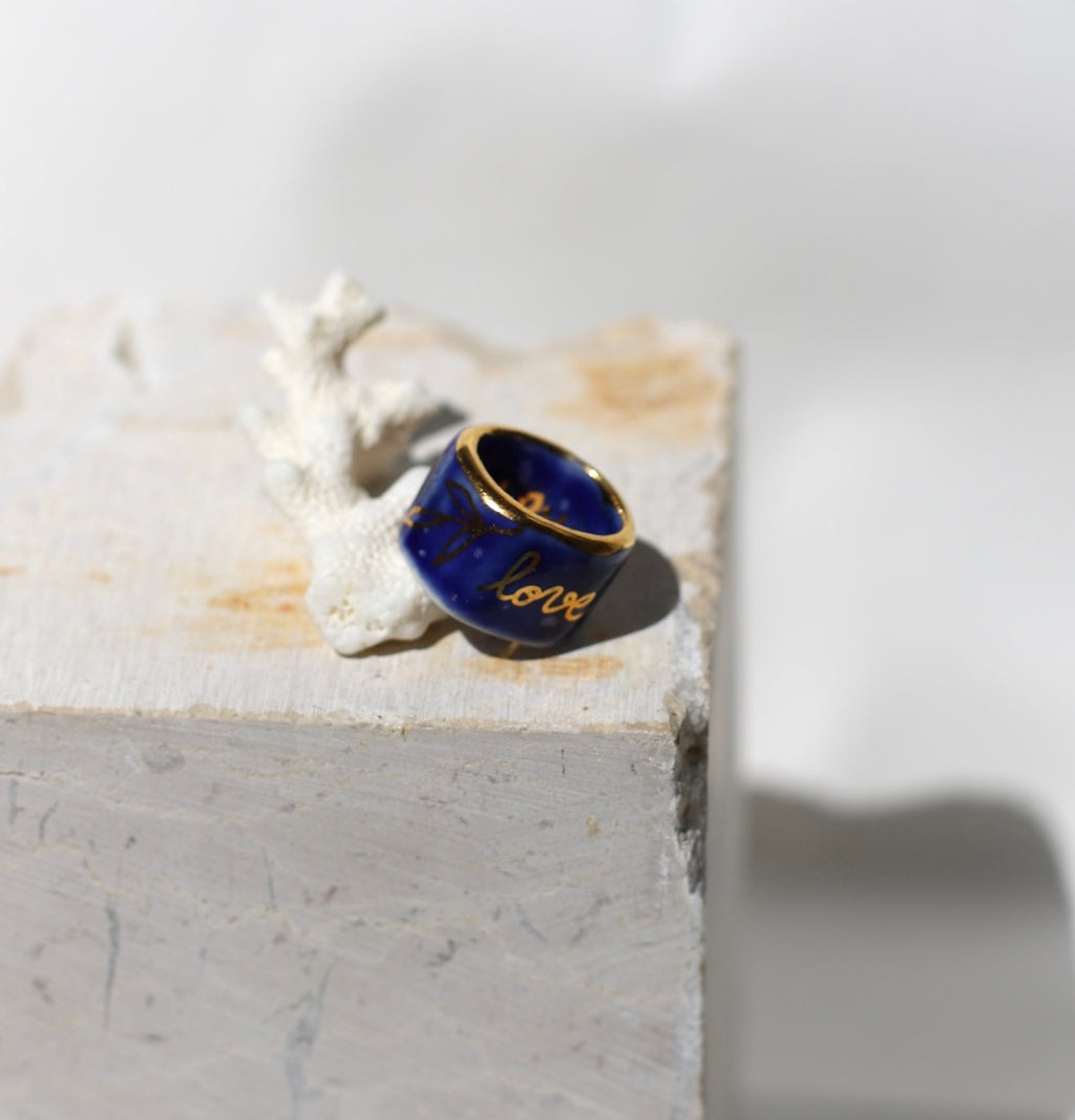 bague en porcelaine bleu nuit émaillée en taille 51FR. Avec de liserés en or brillant Inscription "love" écrit en lettres d'or, entouré de détails floraux, peints à la main.