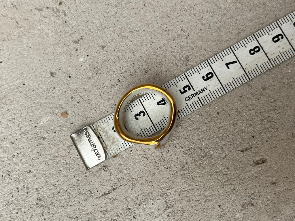 Bague asymétrique en porcelaine blanche émaillée en taille 52FR avec un motif coeur ex-voto peint à la main avec des détails en noirs et à l'or liquide. Fait à la main à Lyon
