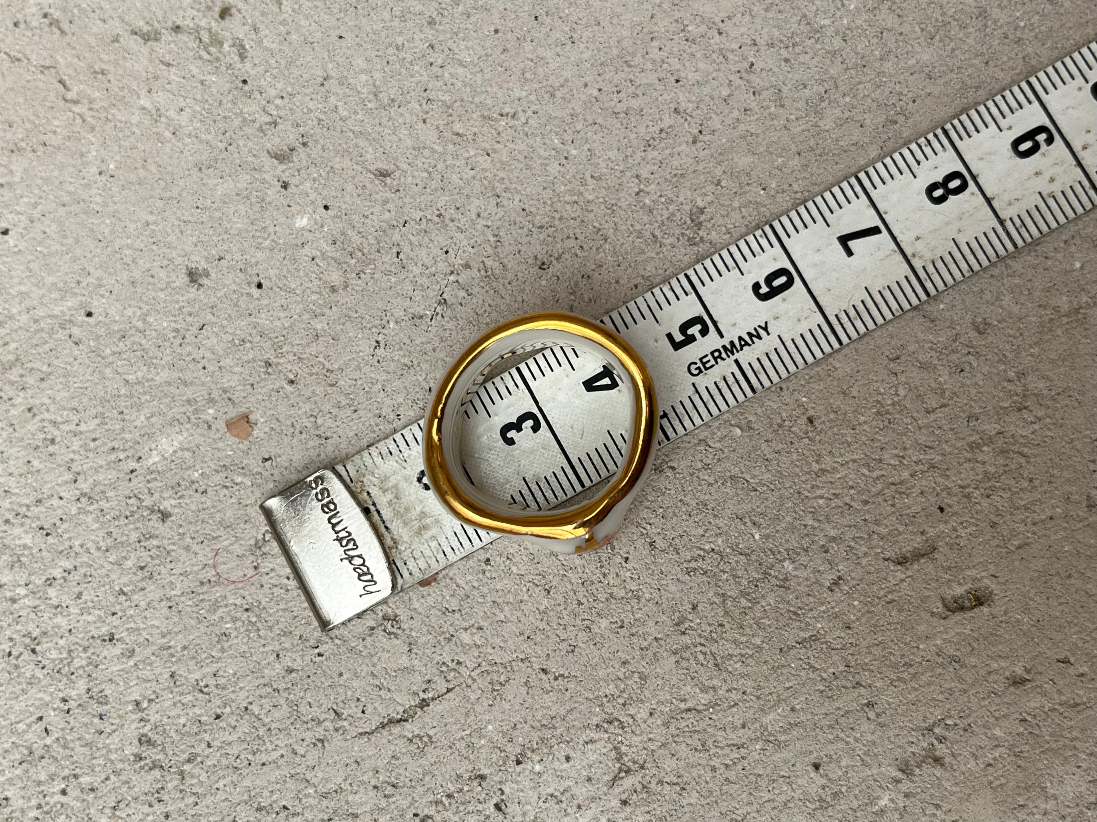 Bague asymétrique en porcelaine blanche émaillée en taille 52FR avec un motif coeur ex-voto peint à la main avec des détails en noirs et à l'or liquide. Fait à la main à Lyon