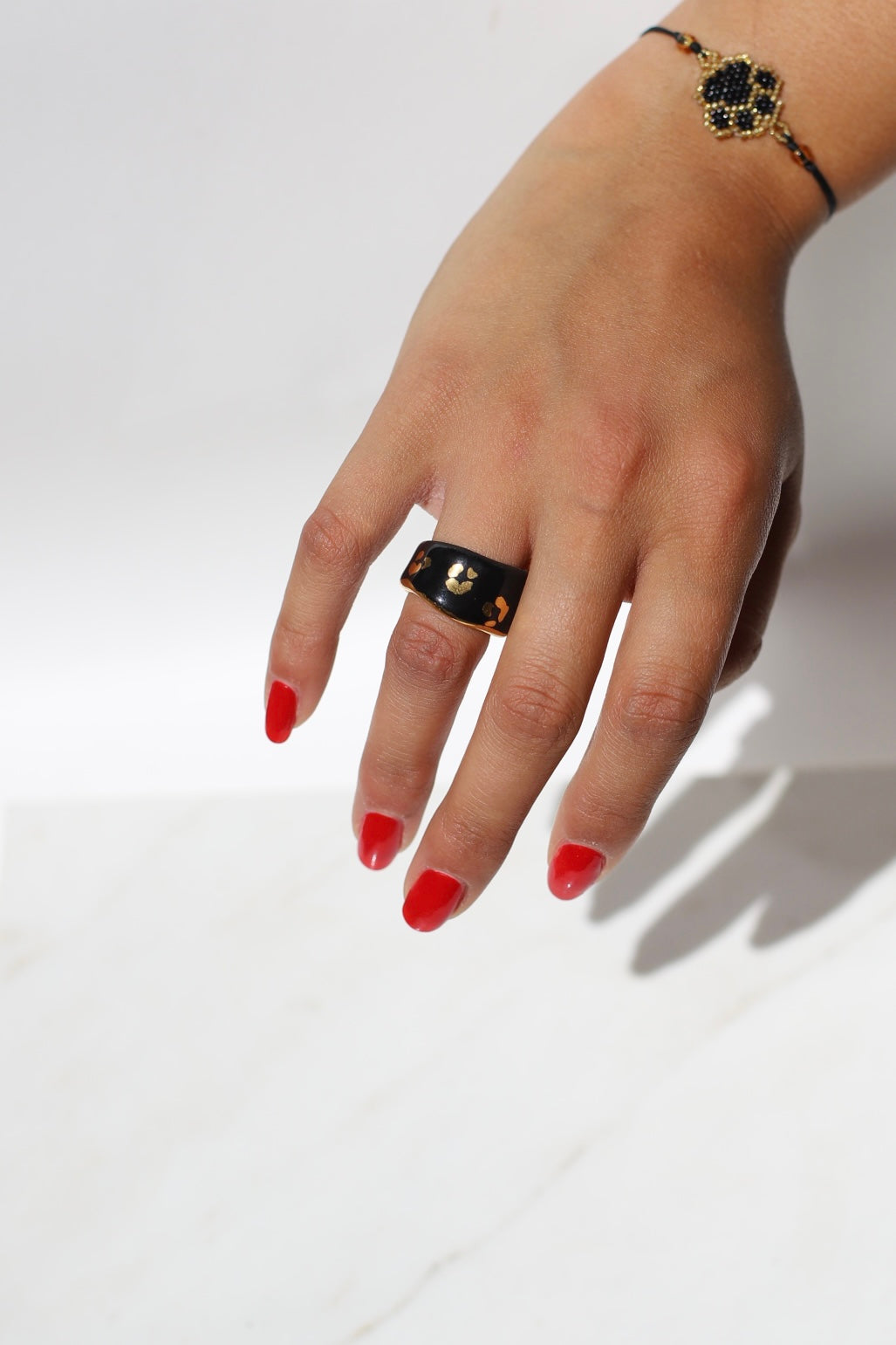 Une bague en porcelaine noir émaillée en taille 49, à motif léopards avec des tâches d'or liquide