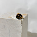 Une bague en porcelaine noir émaillée en taille 49, à motif léopards avec des tâches d'or liquide
