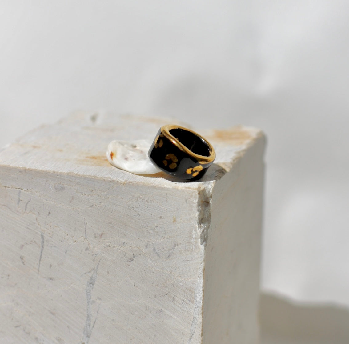 Une bague en porcelaine noir émaillée en taille 49, à motif léopards avec des tâches d'or liquide