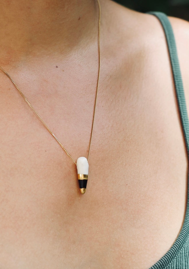 Petit pendentif fait à la main en porcelaine en forme de dents avec du noir et de l'or liquide peint à la main à Lyon 