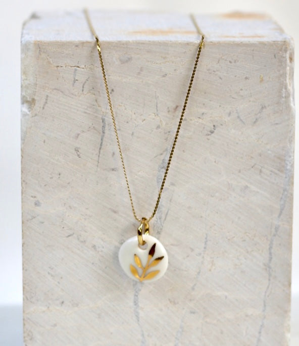 collier fabriqué artisanalement en porcelaine avec un motif floral à l'or liquide peint à la main 