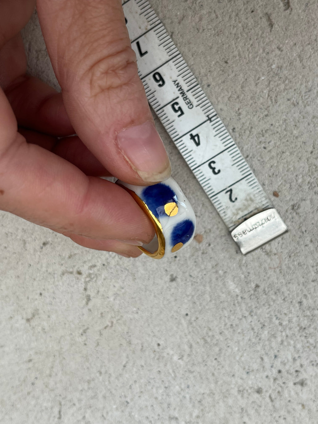 bague en porcelaine blanche émaillée en taille FR51, avec des détails à l'or liquide peint à la main avec un motif à pois bleu nuit et point à l'or précieux.