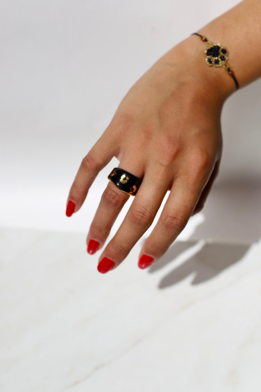 Une bague en porcelaine noir émaillée en taille 49, à motif léopards avec des tâches d'or liquide
