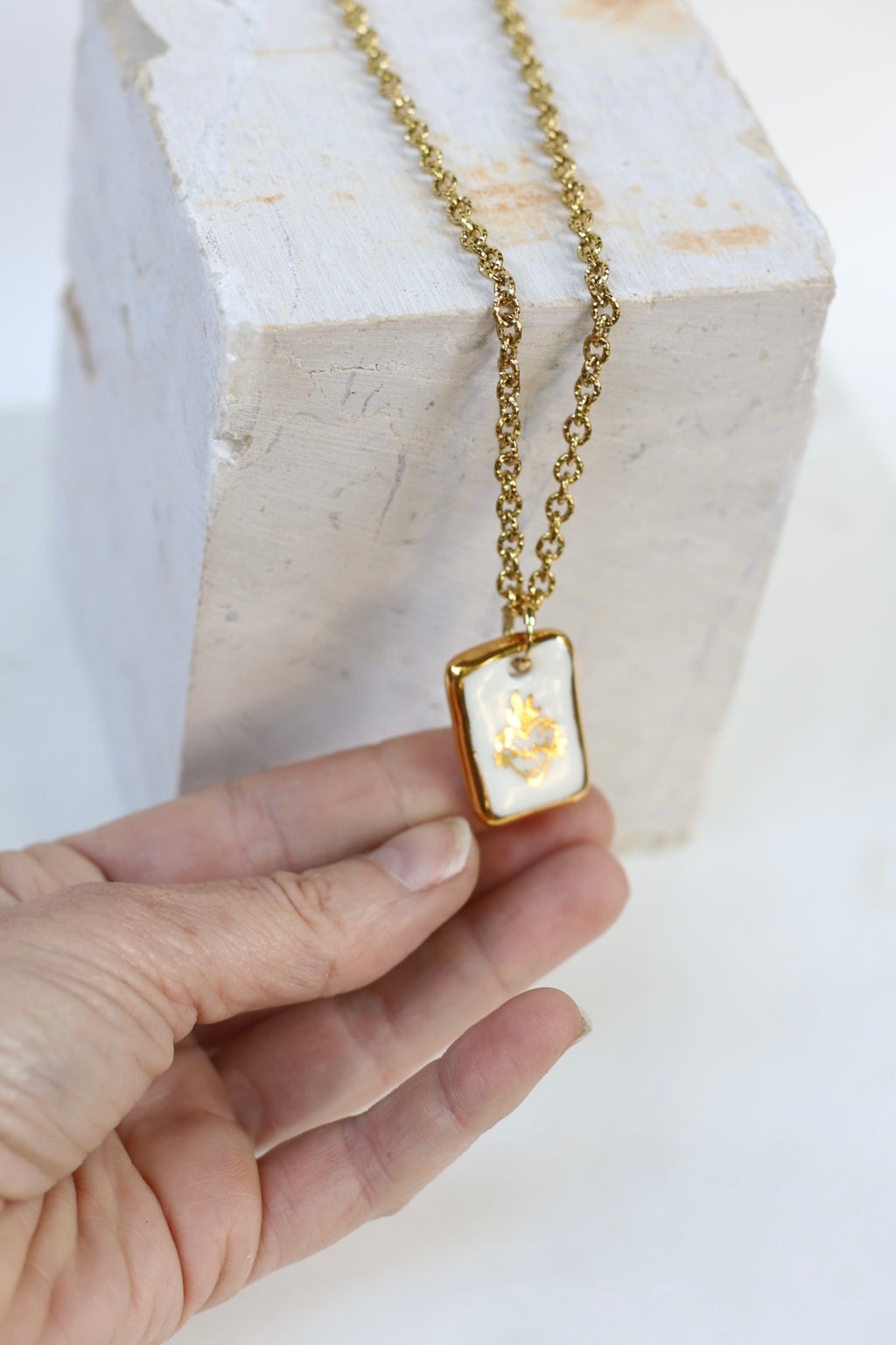Collier à chaîne dorée et avec un motif sacrée en porcelaine blanche ex-voto, bijou de créateur fait à la main 