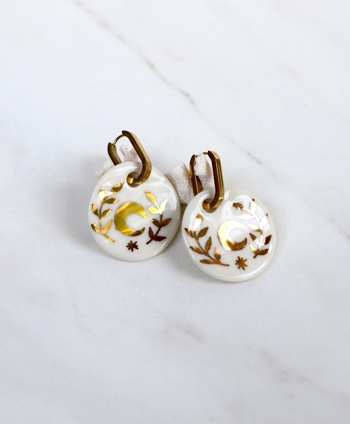 Grande boucle d'oreille en porcelaine avec des touches en or et un motif lune 