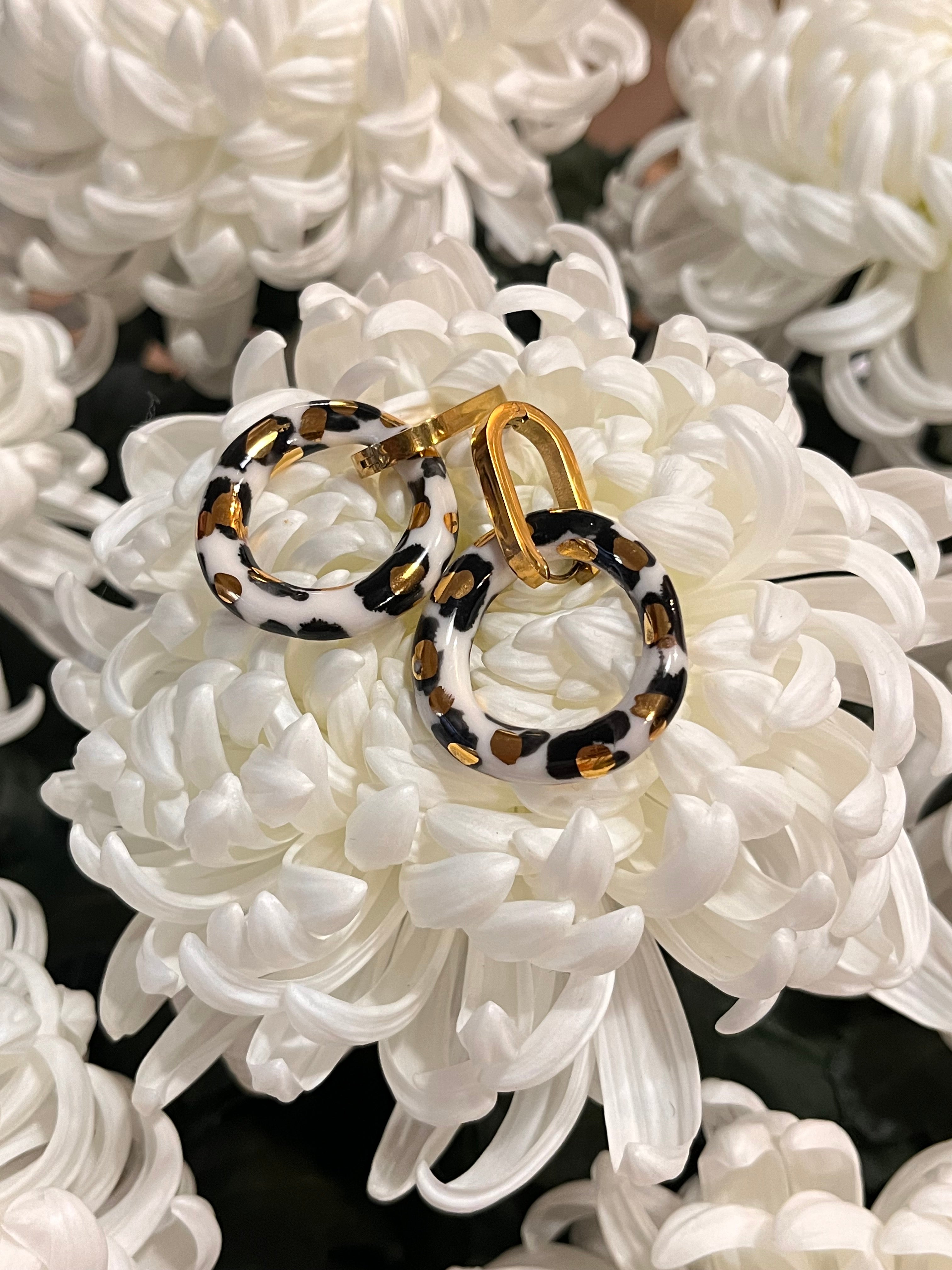 Boucle d'oreille créoles de créateur, en porcelaine avec des touches d'or. 