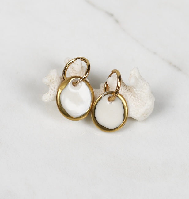 Boucle d'oreille élégante ovale blanche en porcelaine entouré d'or 