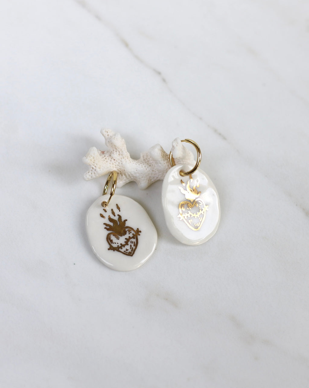 Grandes boucles d'oreilles pendantes HEARTVOTO en porcelaine blanche avec motif ex-voto sacré cœur en or liquide fait main. Bijou de créateur français au style rock et bohème.