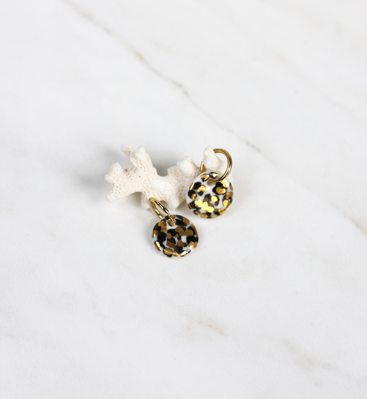 Bijoux de créatrice en porcelaine fais main avec des détails en or avec un motif léopards 