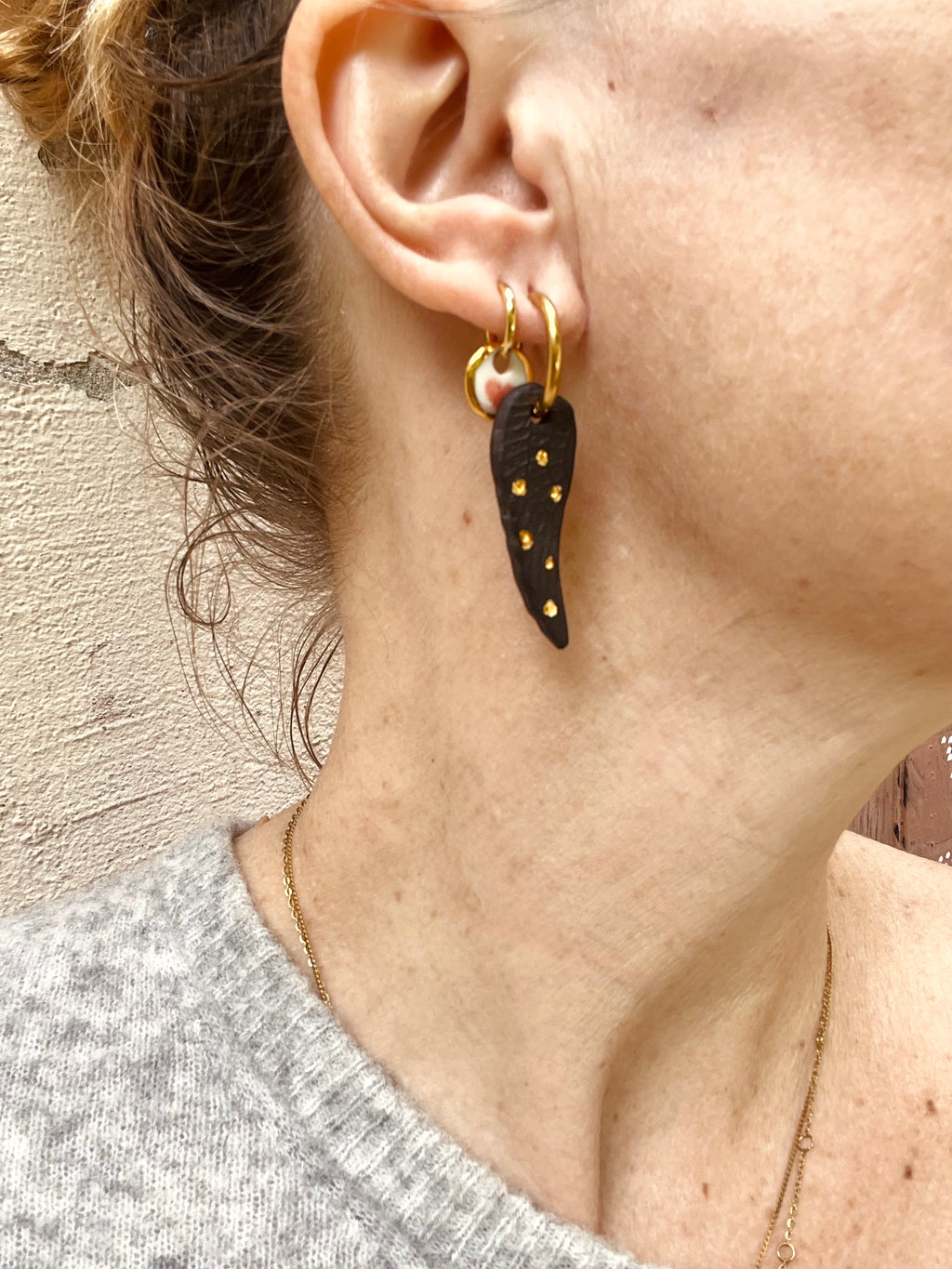  paire de boucles d'oreilles en forme d'ailes fabriqué à la main en porcelaine noire mate texturée, parsemés de petits points d'or liquide 