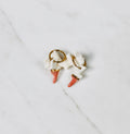 Une paire de boucles d'oreilles mini avec des pendentifs en forme d'éclair en porcelaine bicolore blanche et rose saumon, séparés par une ligne d'or fin.