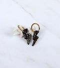  Paire de boucles d'oreilles dorées avec des pendentifs en forme d'éclair noir ornés de petites touches dorées à l'or fin.