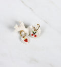 La fraîcheur d’une paire de boucles dépareillée en porcelaine, avec une fraise et des cerises dessinées 