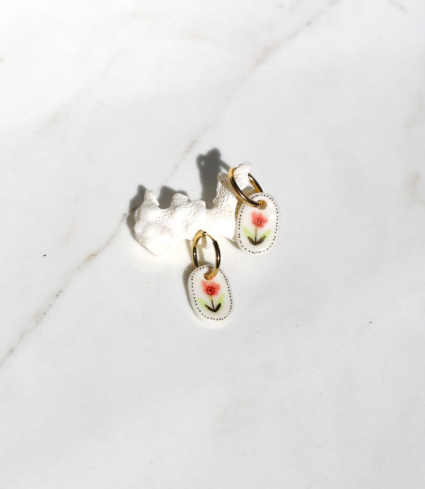 Boucles d’oreilles en céramique avec un dessin de fleur rose 