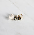 paire de boucles d'oreilles pendantes noir avec un motif coeur en or liquide dessinée à la main. 