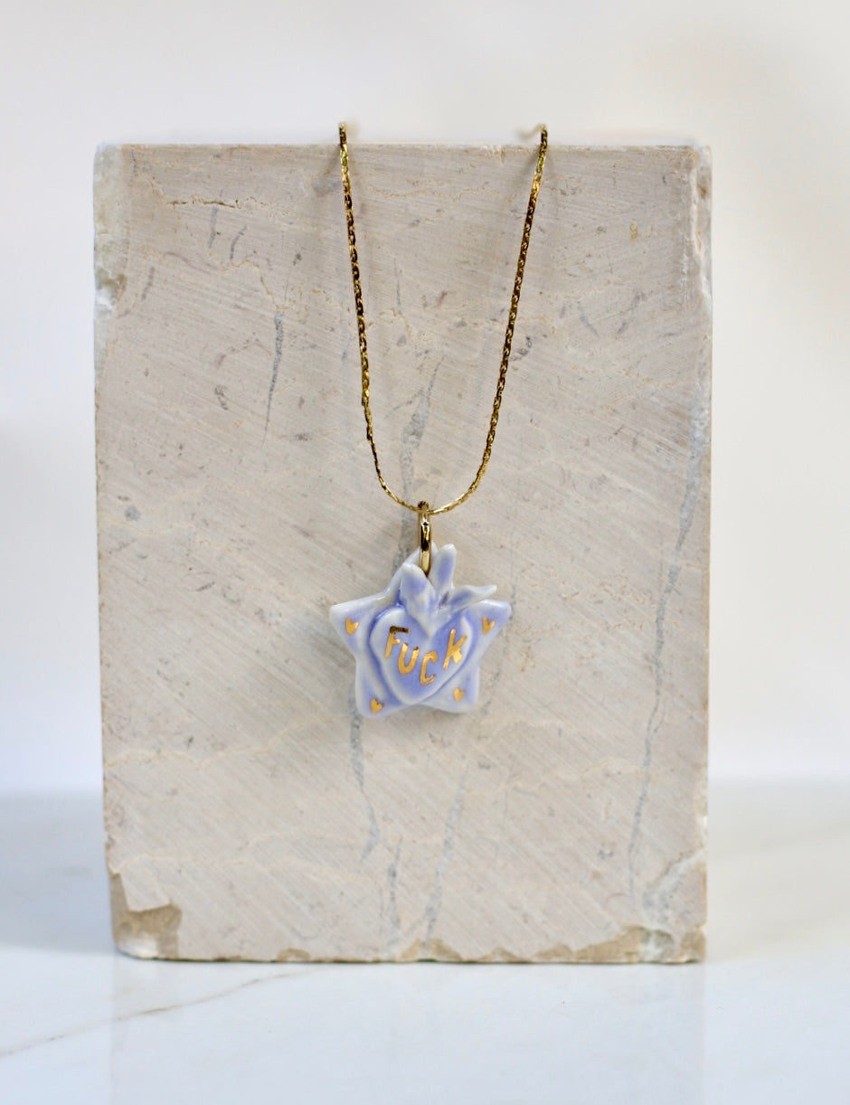 Collier en forme d'étoile ex-voto couleur bleu ciel avec inscription fuck peint à l'or liquide 