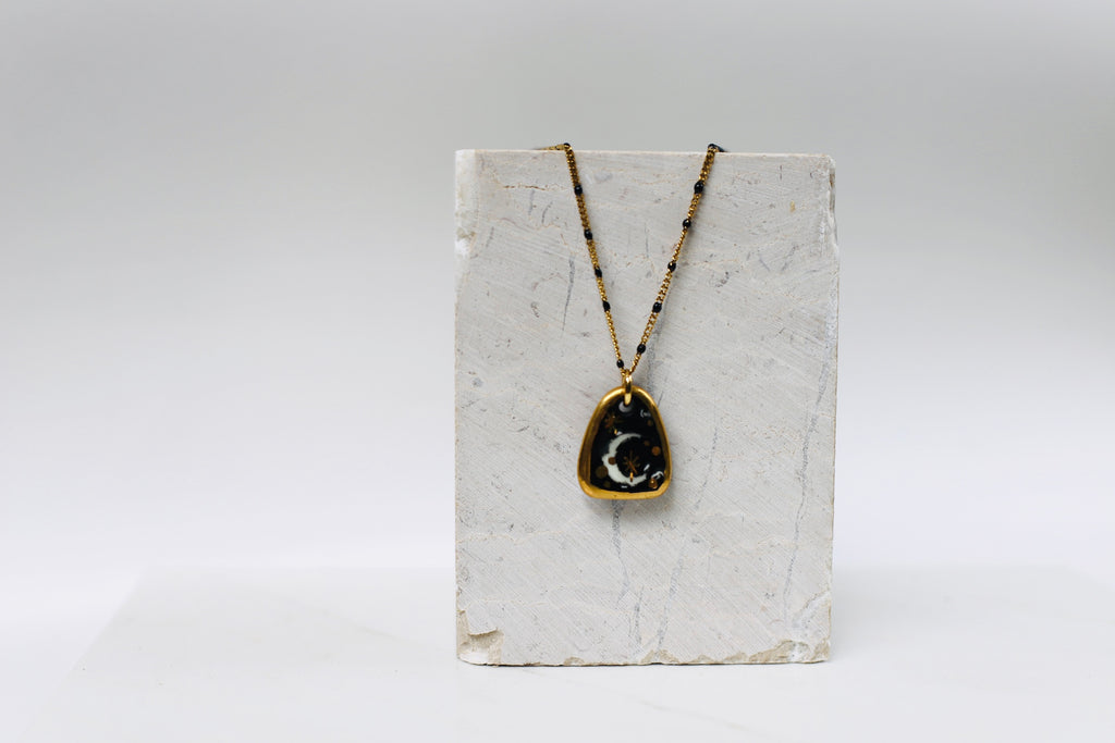 Collier de créateur en porcelaine noir avec des étoiles d'or 