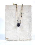 Collier en acier inoxydable avec des perles avec un charms en porcelaine travaillé dans la masse à la main 