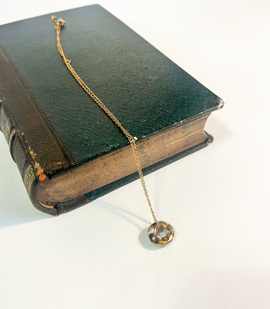 Collier rock en céramique avec un donut avec des touches d'or 