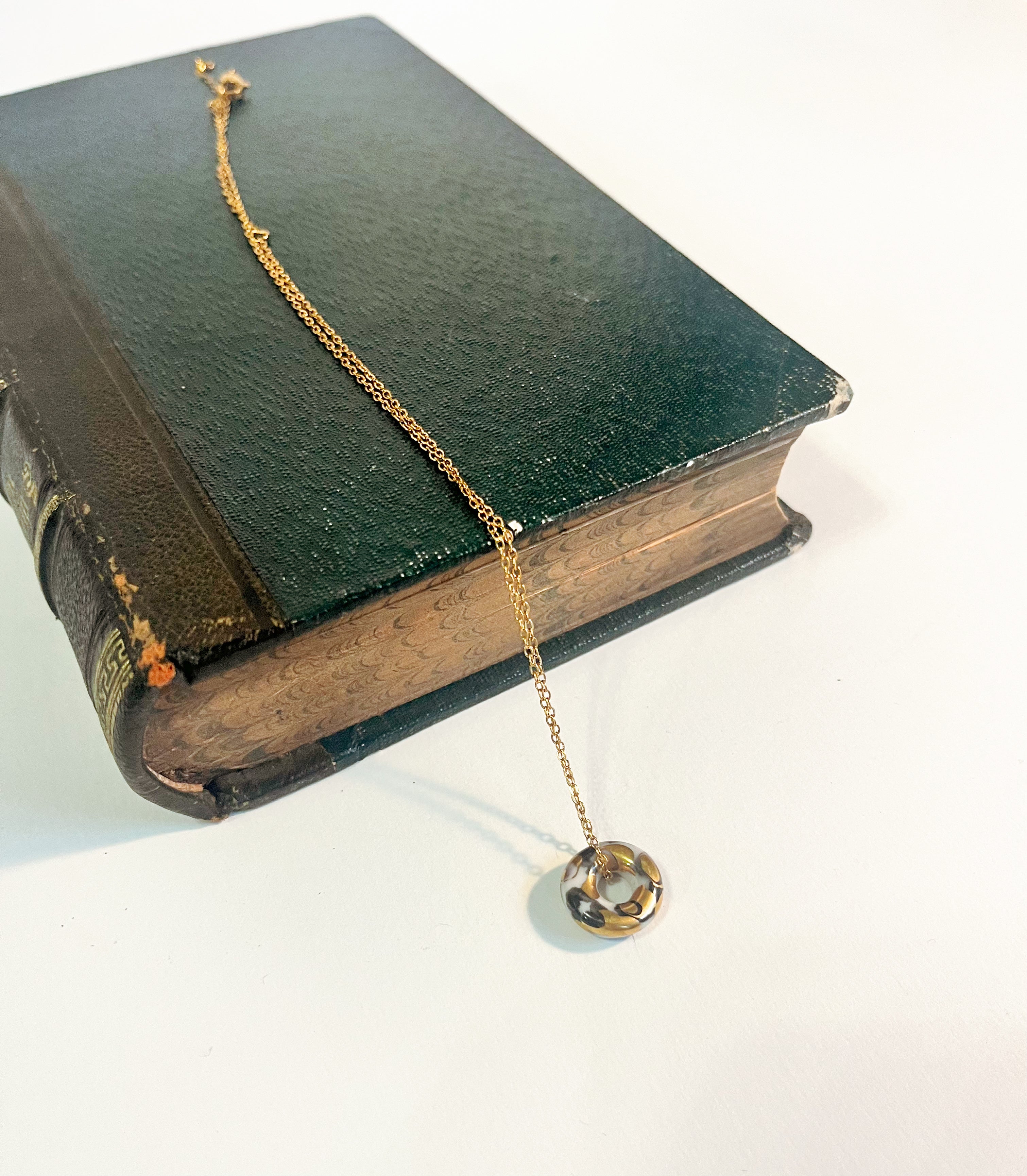 Collier rock en céramique avec un donut avec des touches d'or 