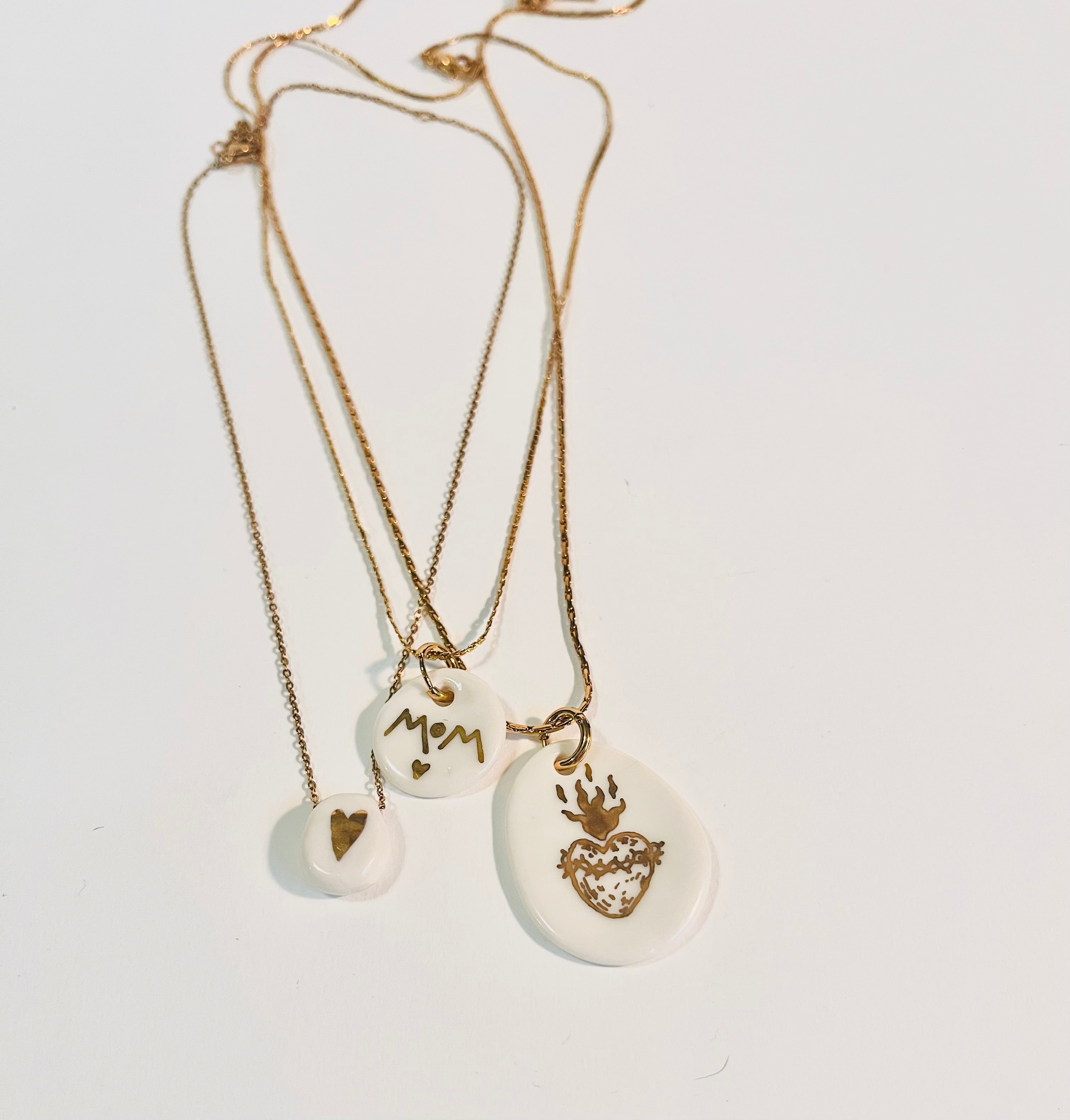 Collier de créateur en acier avec un pendentif en porcelaine avec un coeur en or comme motif 