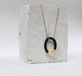 Collier créole avec une fine chaîne dorée et d'un pendentif anneau en porcelaine noire mate fait main.