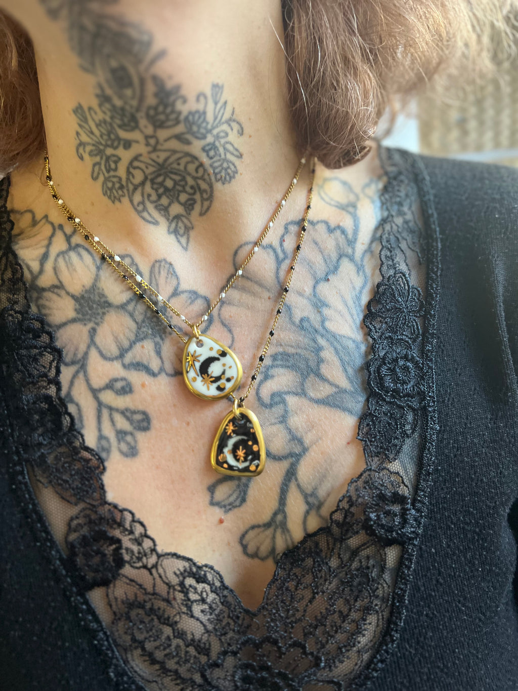 Jolie collier en acier avec un des étoiles et une lune en porcelaine avec des touches d'or 