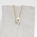 Collier fait main avec un coeur en porcelaine avec des touches d'or 