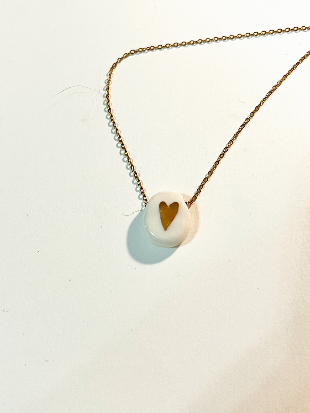 Petit collier en forme de coeur  en porcelaine avec un motif coeur en or liquide fait main 