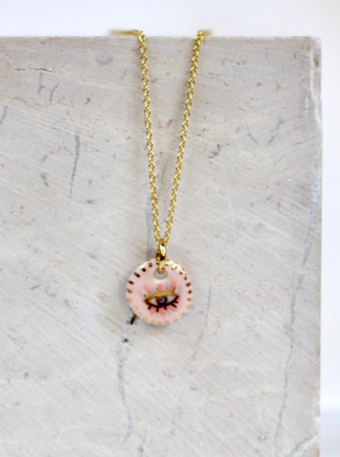 Collier en porcelaine rose avec un dessin oeil protecteur peint à la main à l'or liquide 