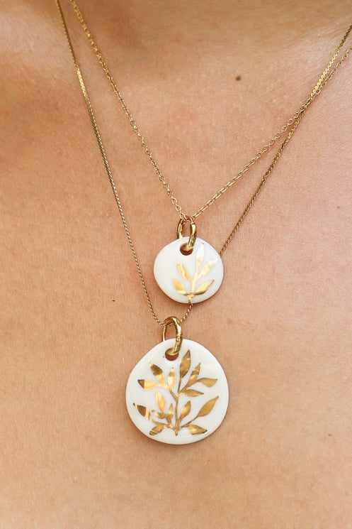 collier en porcelaine fait main en porcelaine blanc avec un motif floral peint à l'or liquide 