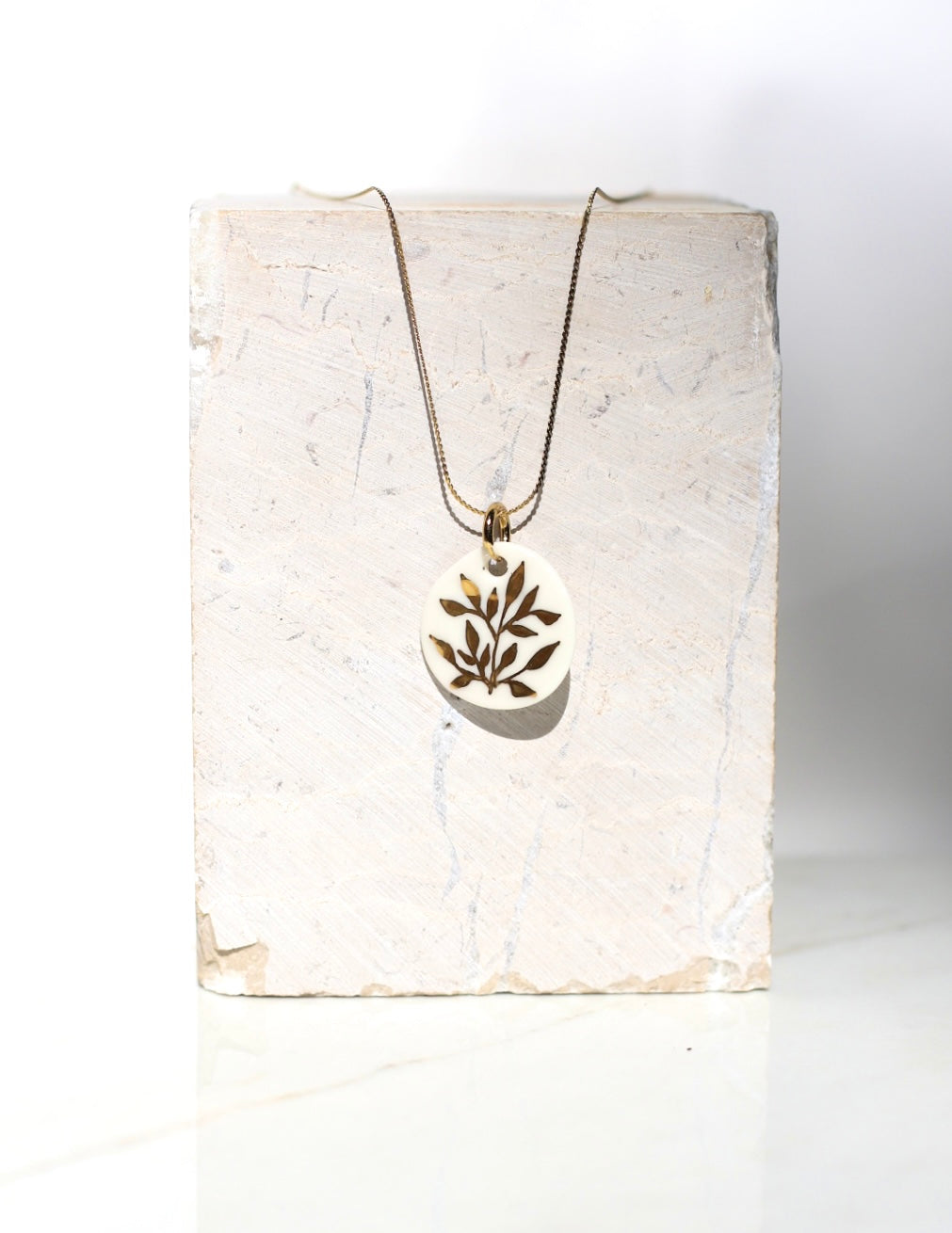 Collier en acier inoxydable avec un pendentif en porcelaine blanc fabriqué à la main avec un motif floral peint à l'or liquide 