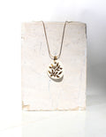 Collier en acier inoxydable avec un pendentif en porcelaine blanc fabriqué à la main avec un motif floral peint à l'or liquide 