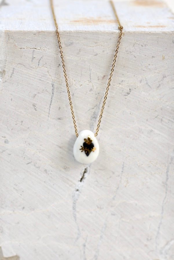 collier avec un pendentif à motif ex voto noir en porcelaine, réalisé à la main avec des détails en or liquide 
