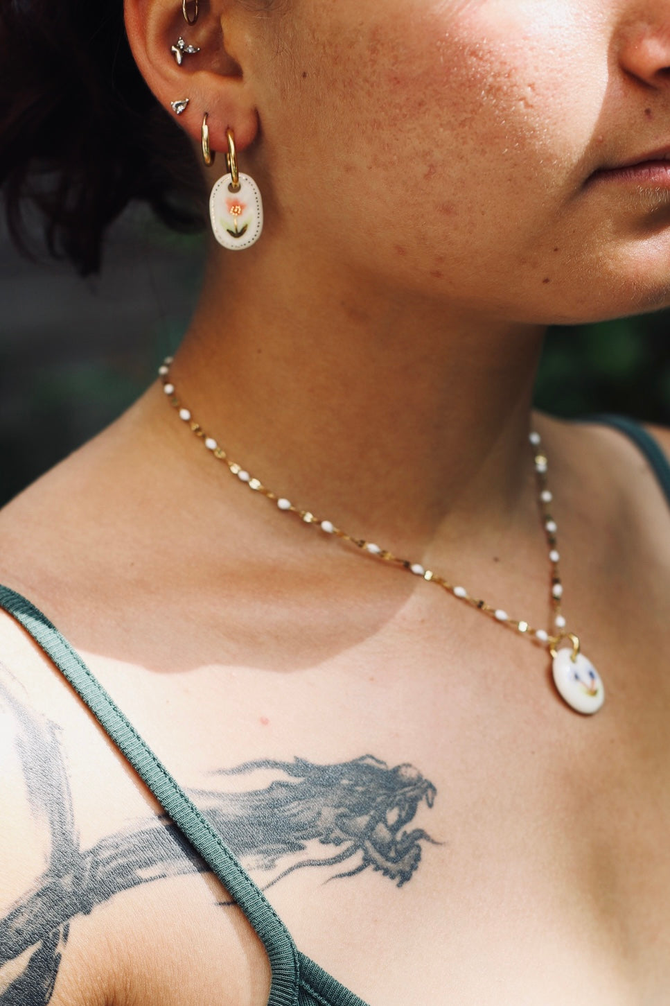 Collier en céramique fais à la main, avec un motif floral peint à la main aux couleur orange et violet
