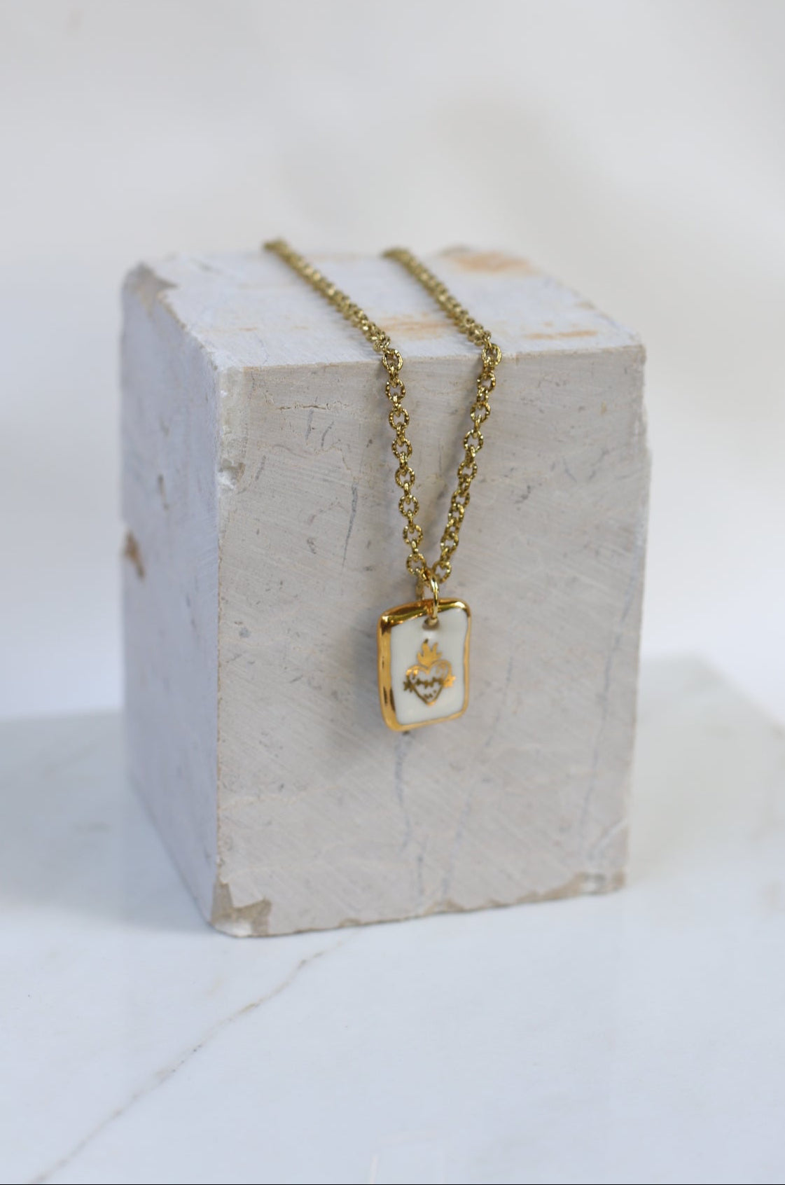 colliers tendance en porcelaine fait main avec un motif coeur ex-voto en or liquide 