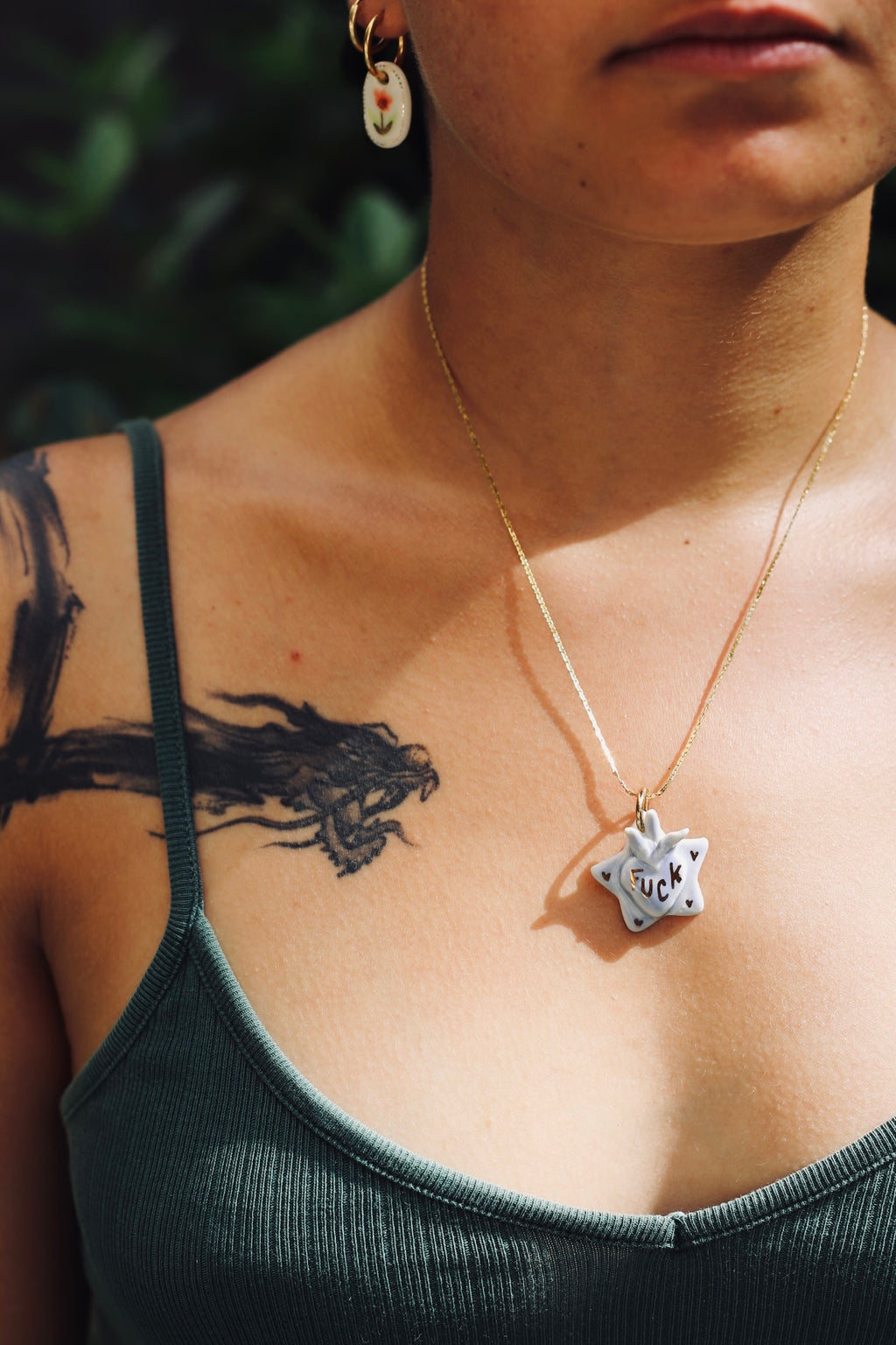 Collier en porcelaine avec un motif ex voto fait à la main avec inscription fuck peint à l'or liquide 