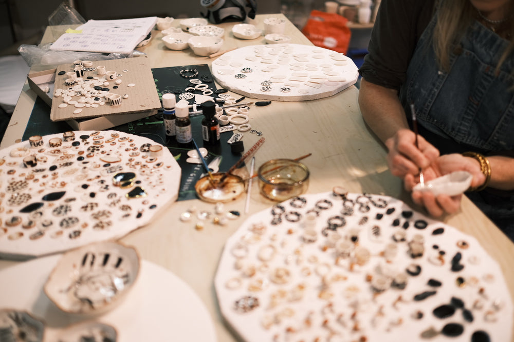 Artiste au travail, céramiste au travail, dessin à l’or liquide sur bijoux et pièces en porcelaine 