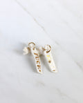 Paire de longues boucles d'oreilles pendantes asymétriques en porcelaine blanche pour femme. Barrettes verticales ornées des mots FUCK et HOPE écrits en lettres d'or fin avec un mini cœur doré